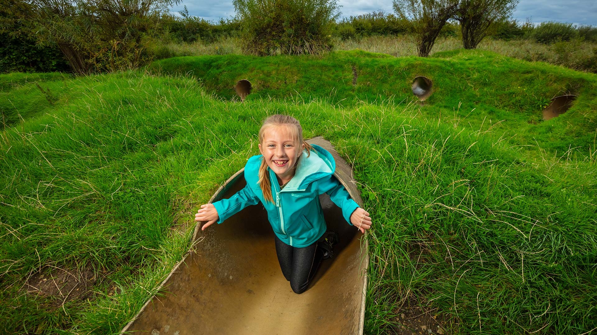 A girl exits a small tunnel